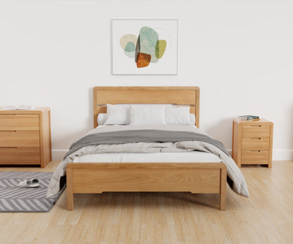 Curve Bed Frame lifestyle image taken from the footend, featuring the bed made up alongside other products from the Julian Bowen Curve range.