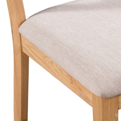 Julian Bowen Curve Oak Dining Chair. Angled close-up cut-out image on a white background.