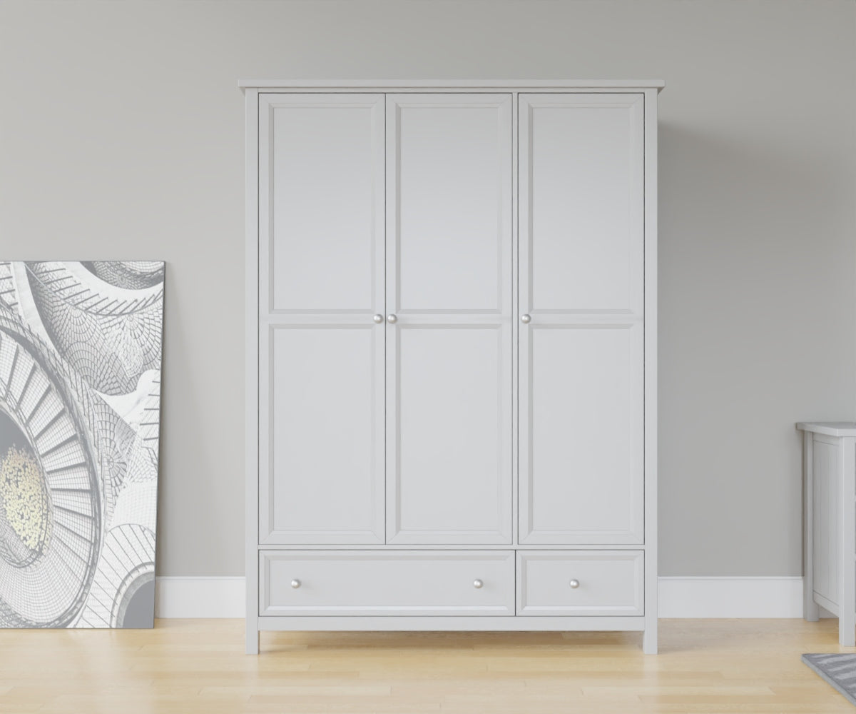 Maine 3 Door Wardrobe in Grey has 3 tall doors and 2 drawers at the bottom. This lifestyle image features other products from the Julian Bowen Maine range.