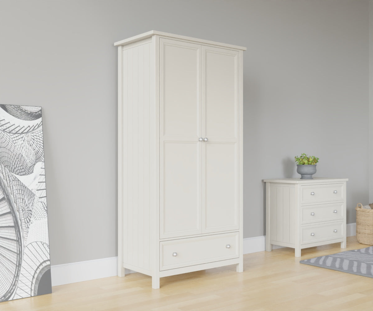 Maine 2 Door Wardrobe in white has 2 tall doors and 1 drawer at the bottom. This lifestyle image features other products from the Julian Bowen Maine range.
